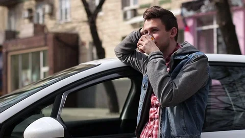 A guy drinks coffee next to a car Stock-Footage 74373227