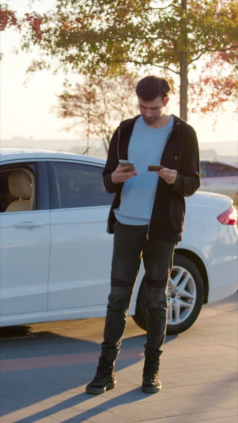 Guy driver unlocks automobile door standing against vehicle Stock Footage 300548548