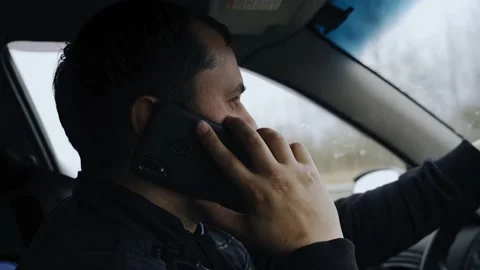 The guy is driving a car and talking on a mobile phone Stock Footage 152913382