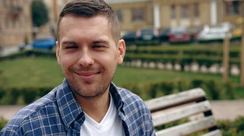 Guy At Dusk. Pan to good looking young man who looks around then smiles for the Stock Footage 62628563