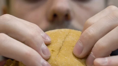 Guy eating a chicken burger 库存影片 114753653