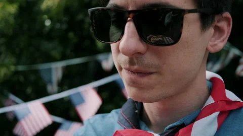 Guy eating a hot dog with a tiny USA flag on it Stock Footage 133616233