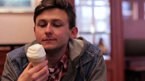 The guy is eating ice cream in a cafe. 動画素材 74375335