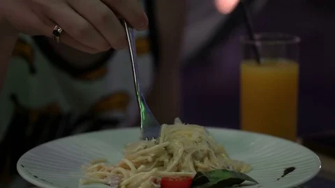 The guy is eating pasta in a restaurant. Stock Footage 79652713