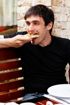Guy is eating pizza with an appetite Stock Photos