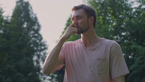 A guy eats an apple in the park Stock Footage 156324351