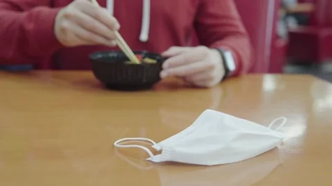 Guy eats an Asian dish of rice and chicken curry from disposable plastic Stock Footage 161820109