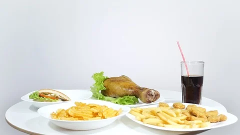 Guy eats chips and other fast food from the table of the house. Stock Footage 122819339