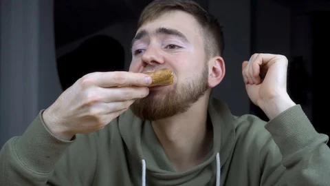 The guy eats a delicious pizza with his mouth full. Vidéo 120756985