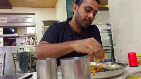 Guy eats his food while seated at the cafe Stock Footage 299785748
