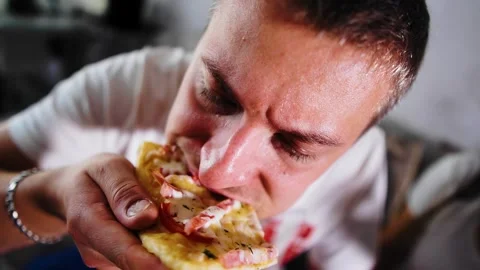 The guy eats a piece of pizza very savorily and appetizingly Stock Footage 312005941