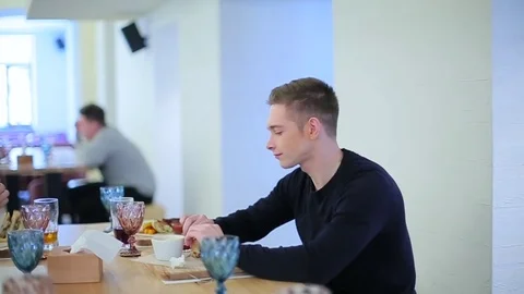 Guy eats sandwich in restaurant Stock Footage 71656217
