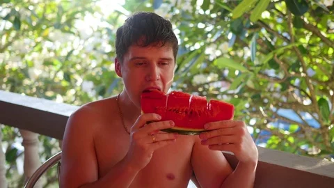 The guy eats a sweet juicy watermelon on a hot summer day 库存影片 74592621