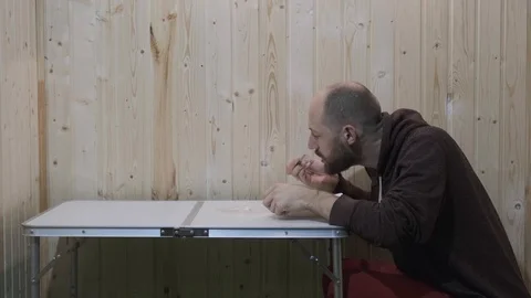 The guy eats at the table from a plate, then takes it in his hand, eats further Stock Footage 119832147