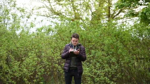 Guy emotionally looking at something in notepad against green background Stock Footage 129684301