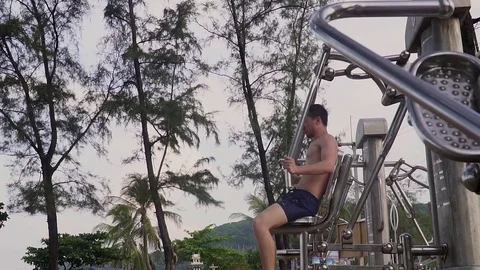 The guy is engaged in street exercise equipment Stock Footage 120050074