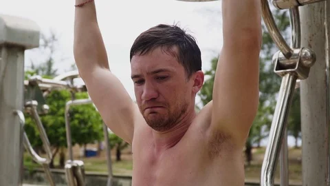 The guy is engaged in street exercise equipment Видео 120050113