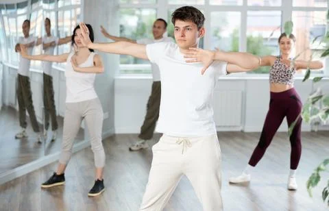 Guy enjoys active dancing, learns new movements, moves synchronously with Stock Photos