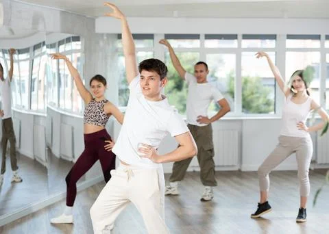 Guy enjoys active dancing, learns new movements, moves synchronously with 스톡 사진