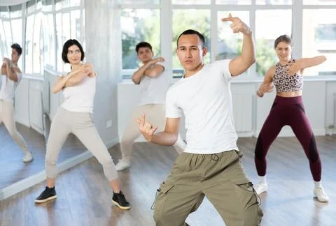 Guy enjoys active dancing, learns new movements, moves synchronously with 스톡 사진