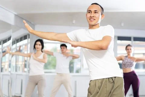 Guy enjoys active dancing, learns new movements, moves synchronously with 스톡 사진