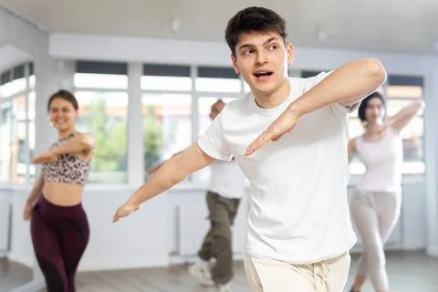 Guy enjoys active dancing, learns new movements, moves synchronously with 스톡 사진