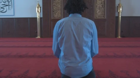 Guy entering mosque and sitting down Stock Footage 88032605