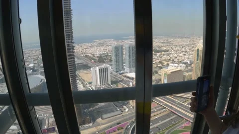 A guy enters a glass elevator in one of the skyscrapers in the center of Dubai Stock Footage 236902247
