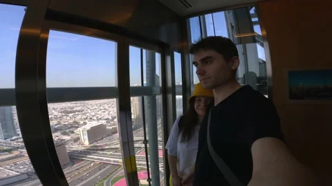 A guy enters a glass elevator in one of the skyscrapers in the center of Dubai Stock Footage 236902972