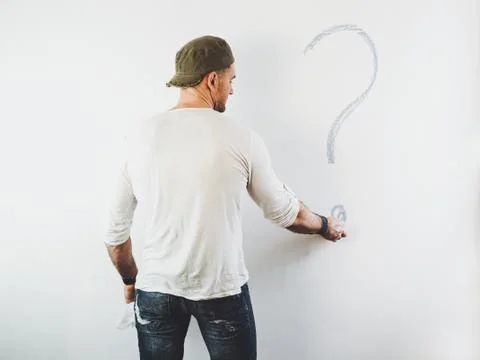 Guy erasing a question mark on a white wall Stock Photos
