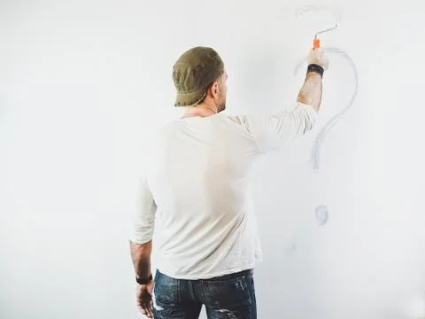 Guy erasing a question mark on a white wall Stock Photos