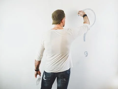 Guy erasing a question mark on a white wall Stock Photos