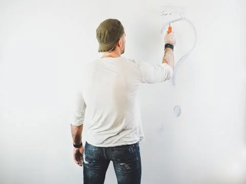 Guy erasing a question mark on a white wall Stock Photos