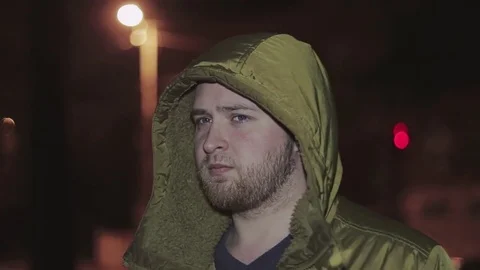 The guy is in the evening park. He lets steam out of his mouth Stock Footage