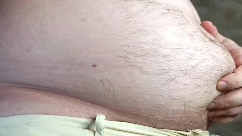 Guy examines his big belly. Concept of body positivity and weight gain Video stock 295497074