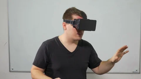 Guy experiencing video game in virtual reality with special equipment headset Video stock 71473313