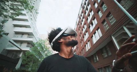 A guy experiencing vr goggles in the business district Stock Footage 201684833