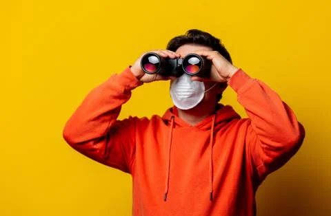 Guy in face mask looking in to binoculars Stock Photos