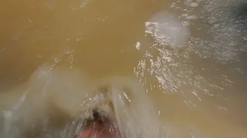 The guy falls backwards into the sea water, standing at a shallow depth. Stock Footage 316845906