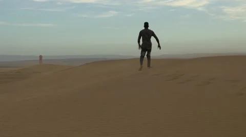 Guy falls on a desert sand 02 Stock Footage 67558562