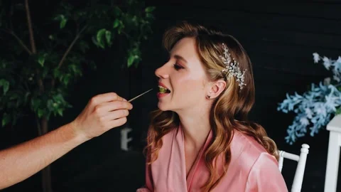 A guy feeds his girlfriend an olive. She eats an olive from a wooden stick. Stock Footage 207905487