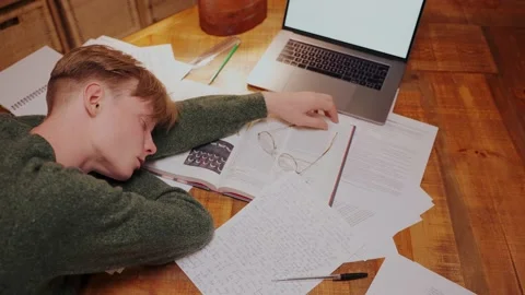 Guy fell asleep while doing homework at the table, lying on books, top view Video stock 164380624