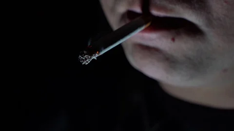 The guy fire on a cigarette on a dark background. Stock Footage 129182334