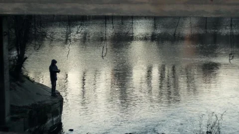 Guy is fishing under a bridge in the fall Video stock 309016204