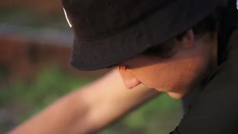 A guy is fixing a quadrocopter on grass, ground. Stock Footage 130740962