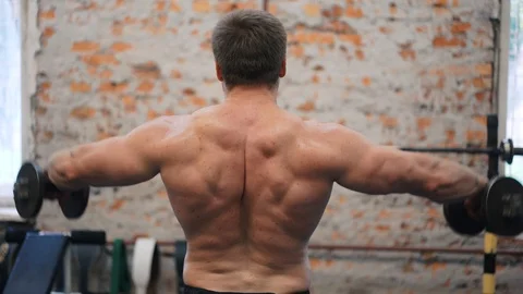 Guy flexing arms with dumbbells in his hands, gym workout, hunky body closeup Stock Footage 94936335