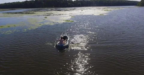 A guy floats on an inflatable boat on the river in summer 2 Stock Footage 265860772