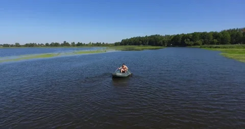 A guy floats on an inflatable boat on the river in summer Stock Footage 265860938