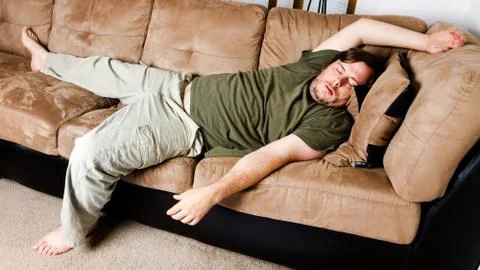A guy flung all over the couch Stock Photos