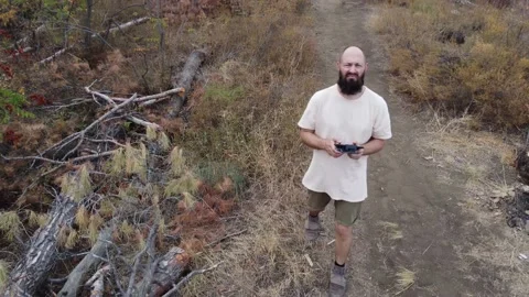 The guy in the forest controls the drone. Video stock 219288157